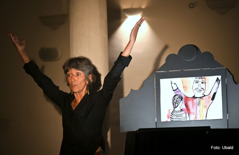 Photographie d'une conteuse devant un kamishibaï