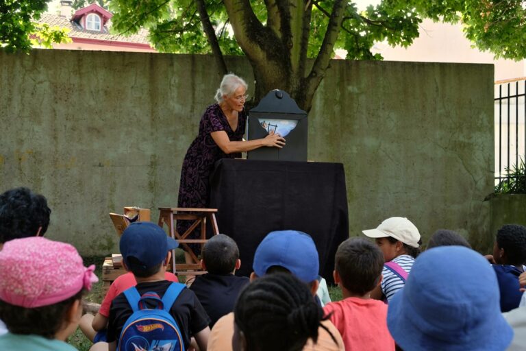 Photographie d'une conteuse racontant un kamishibaï devant un groupe d'enfants
