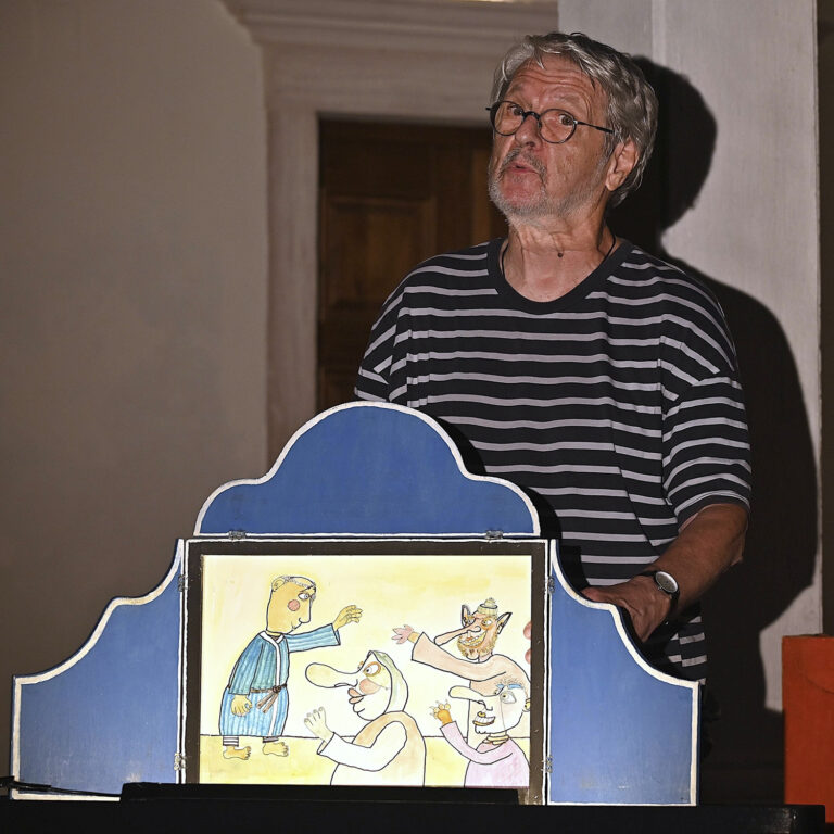 Photo d'un homme racontant un kamishibaï