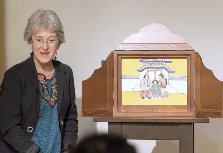 Photo d'une femme racontant un kamishibaï