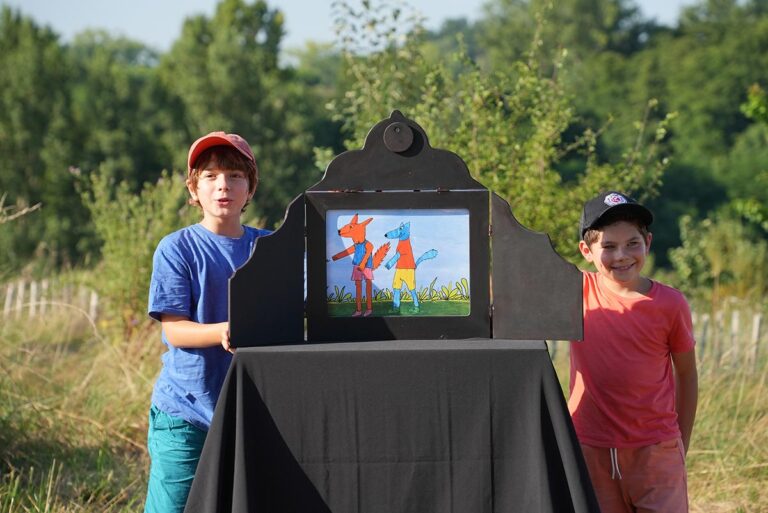 Photo de deux enfants racontant un kamishibaï